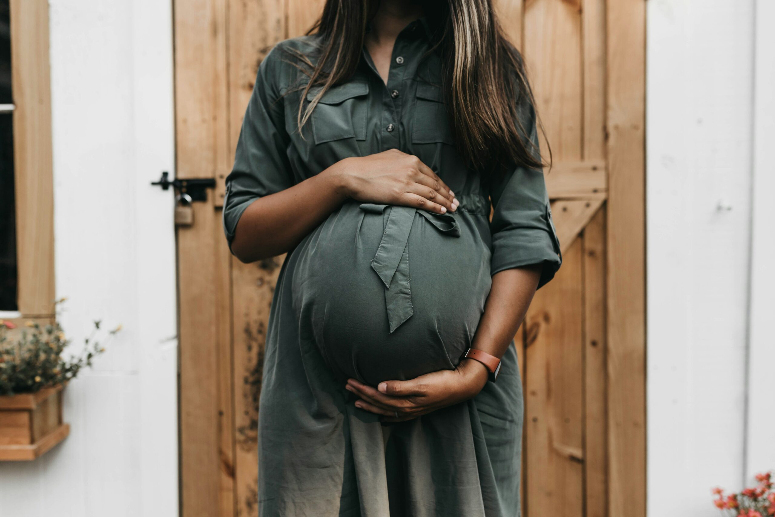 Eine schwangere Frau die ihren Bauch hält